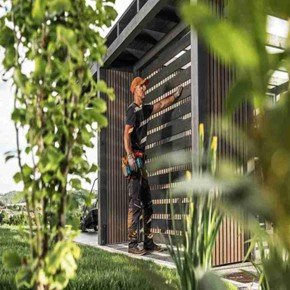 Professional fence contractor installing a modern horizontal cedar fence in a landscaped Rockwall, TX backyard.