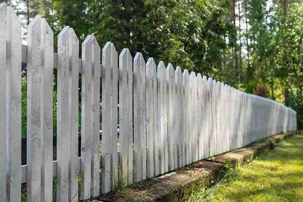 Technician performing fence post replacement and repair service for a residential property in Rockwall, TX