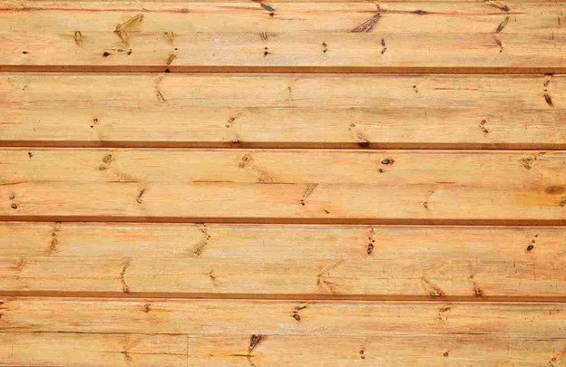 Close-up of vertical pressure-treated pine fence panels with visible wood texture